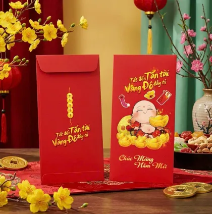 Phối cảnh bao lì xì đỏ chữ Tết đến tấn tài, hình em bé mập ngồi trên thỏi vàng, mặt sau xâu đồng xu — mẫu thiết kế D&P