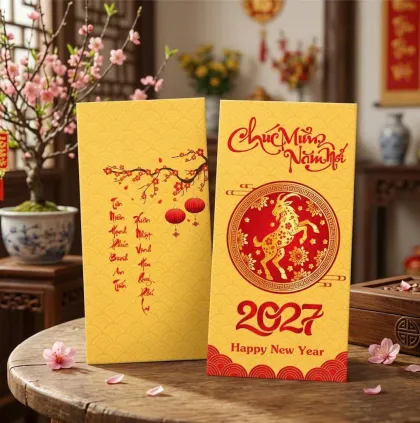 Phối cảnh bao lì xì nền vàng họa tiết sóng, vòng tròn hình dê đỏ và chữ Chúc Mừng Năm Mới 2027 — mẫu thiết kế D&P